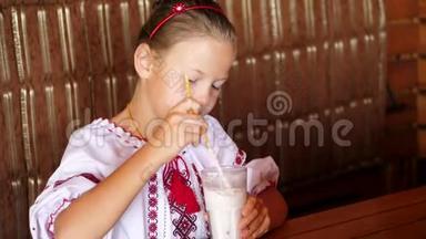 快乐的微笑<strong>少女</strong>孩子在咖啡馆喝奶昔。 她穿着乌克兰民族<strong>服装</strong>，刺绣